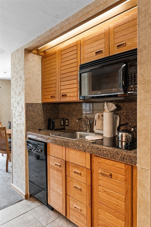 Kitchen with black appliances, a sink, and light t