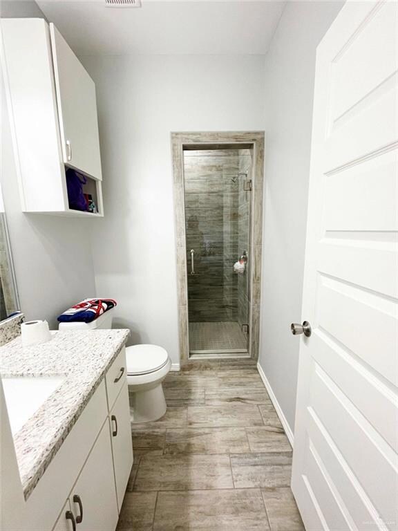 Full bath in the primary featuring a walk-in  shower with a seamless glass shower door and a vanity with work space.