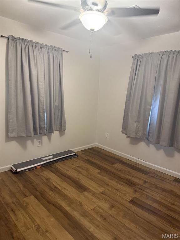 Spare room with dark wood-type flooring and ceiling fan