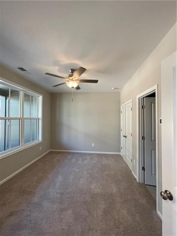 Spare room featuring carpet, a ceiling fan, and baseboards