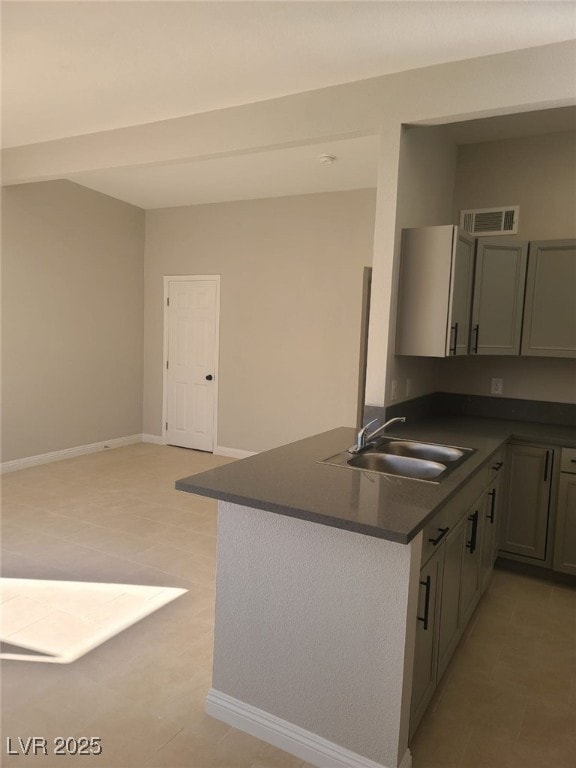 Kitchen featuring dark countertops, visible vents,