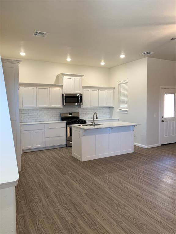 Kitchen with stove, dark wood-type flooring, a cen