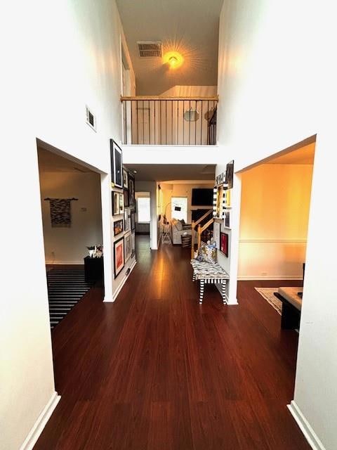 Corridor with a high ceiling and wood finished floors