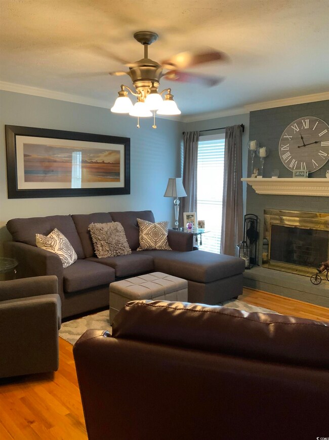 Living room featuring crown molding, ceiling fan, 
