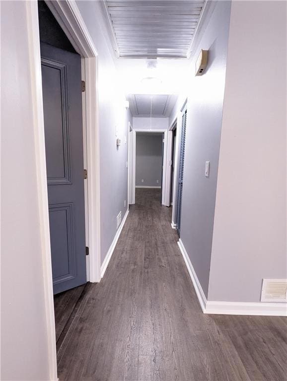 Hallway with attic access and dark wood finished floors