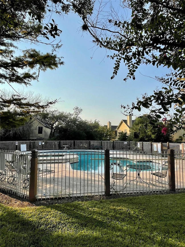Community pool with a patio and fence