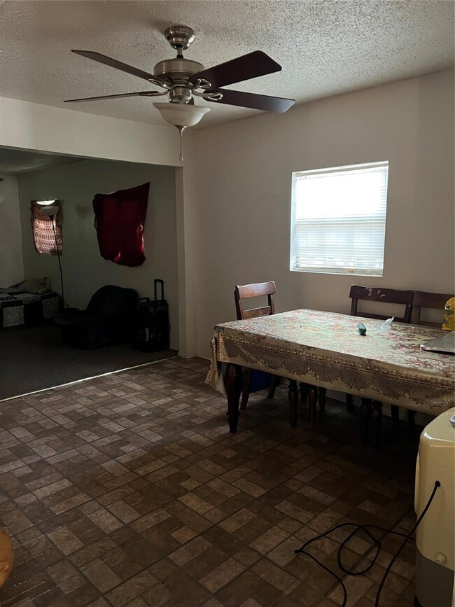 Dining area featuring ceiling fan and a textured c