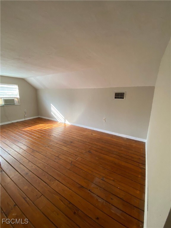 Bonus room featuring hardwood / wood-style floors and lofted ceiling