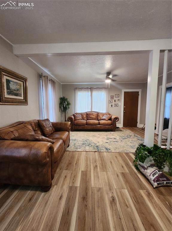Living room featuring beamed ceiling and light woo