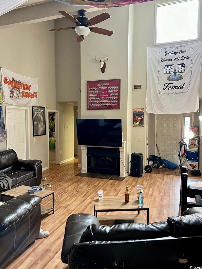 Living room with wood-type flooring and ceiling fa