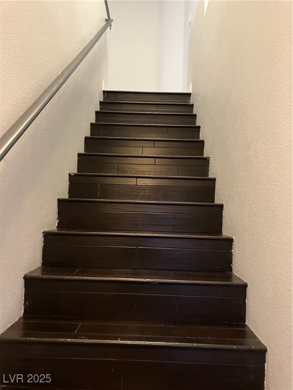 Stairs featuring a textured wall