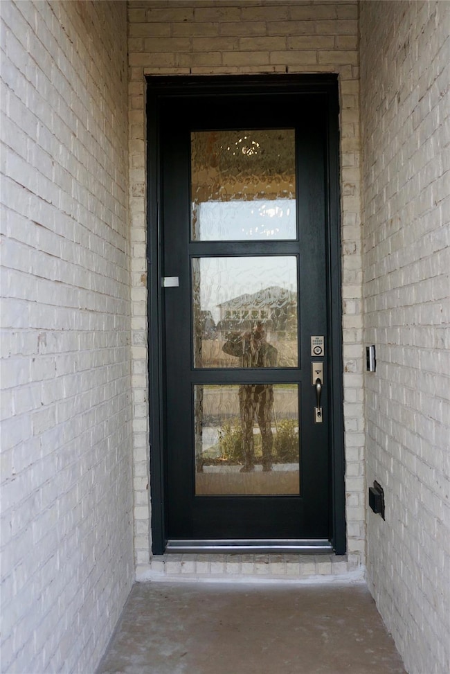 Entrance to property featuring brick siding