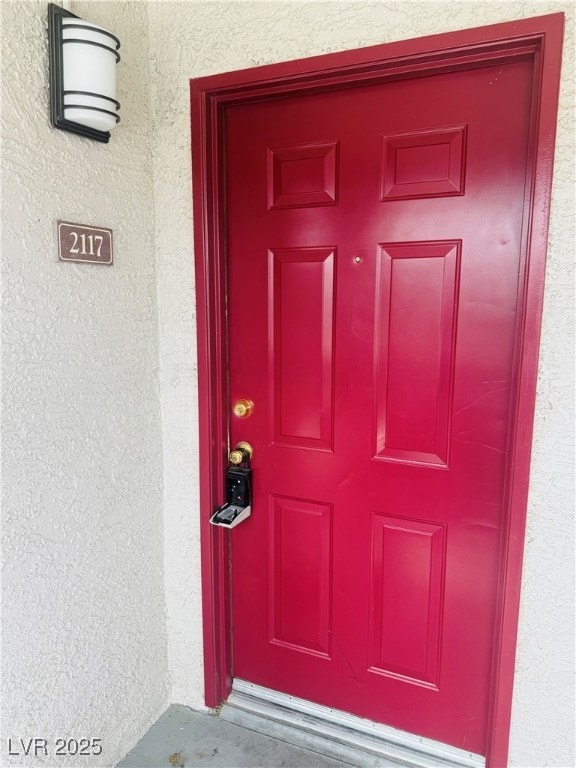 Doorway to property featuring stucco siding