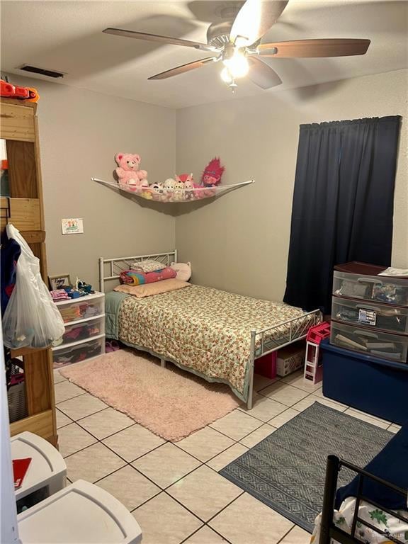 Bedroom with light tile patterned floors and ceiling fan