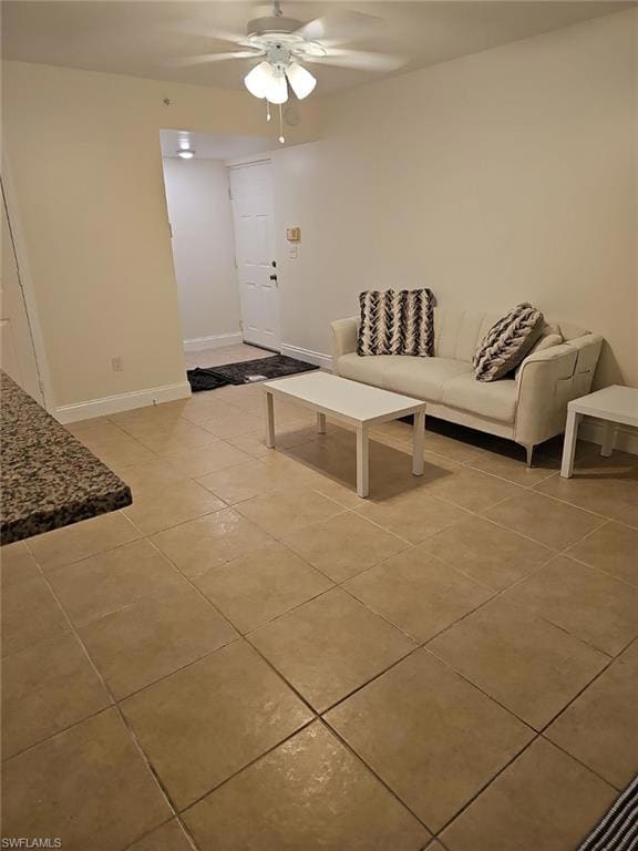 Living room featuring light tile patterned floors and a ceiling fan