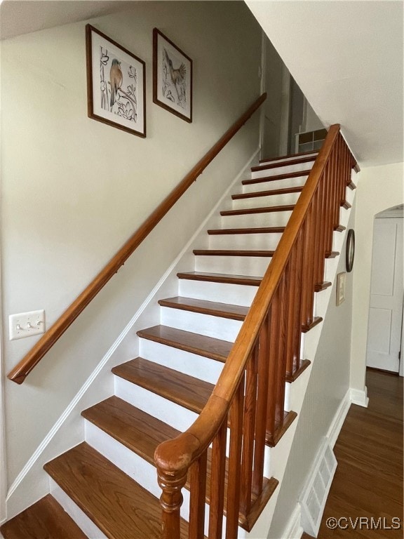Stairs with wood finished floors and baseboards