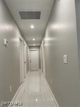 Corridor with baseboards and visible vents