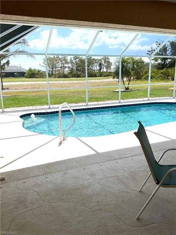 Swimming pool featuring a patio area, glass enclosure, and a lawn