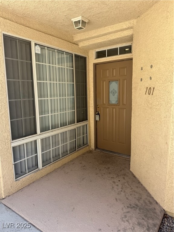 View of exterior entry featuring stucco siding