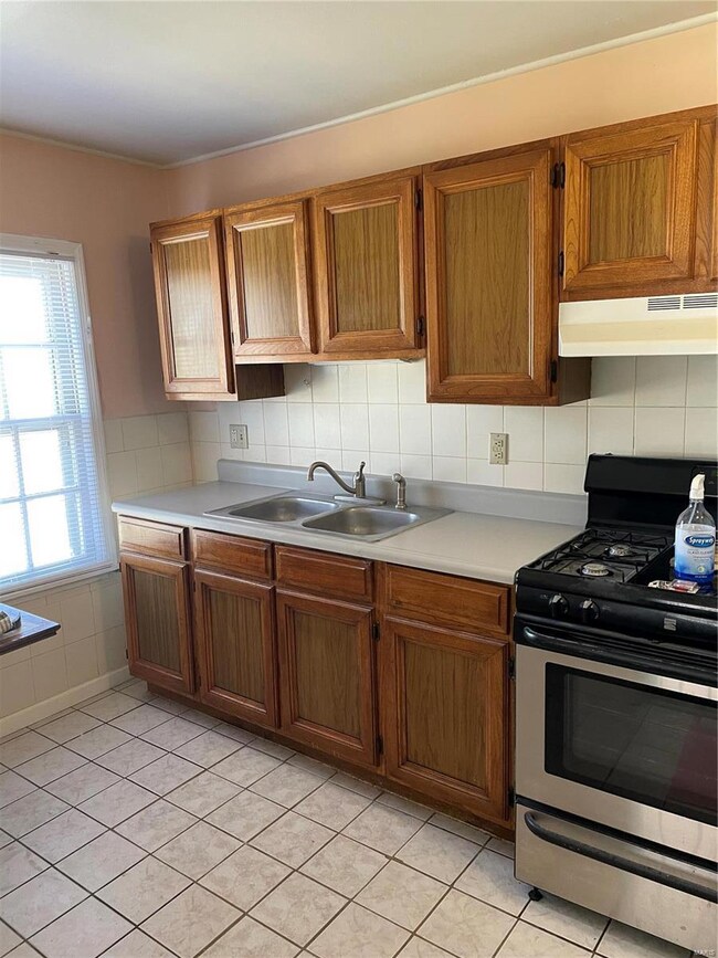 Kitchen features gas stove and refrigerator.