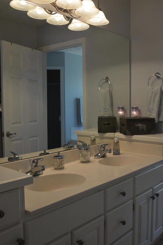 Downstairs Master Bath has tile, synthetic marble counter top, double sink vanity & walk in closet. Recently painted