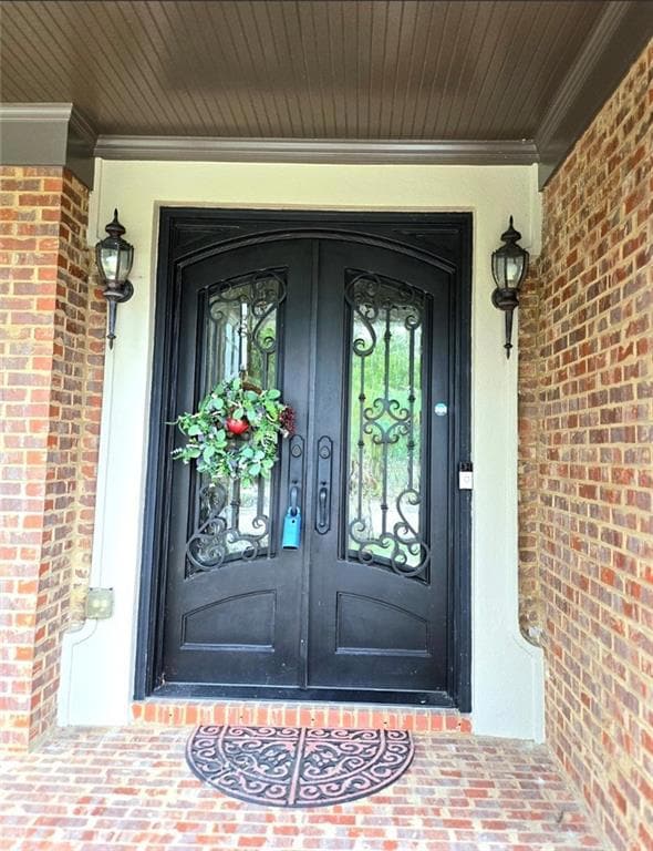 Doorway to property featuring brick siding