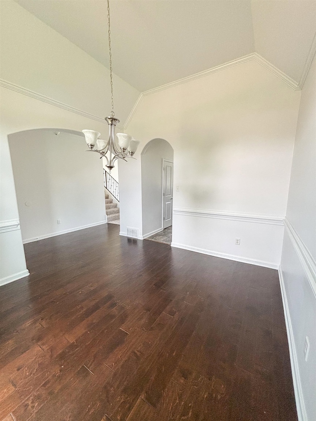 Unfurnished room featuring arched walkways, vaulte
