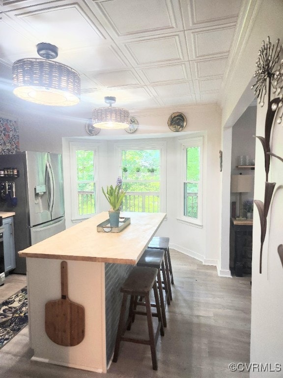 Dining room featuring healthy amount of natural light, an ornate ceiling, and wood finished floors