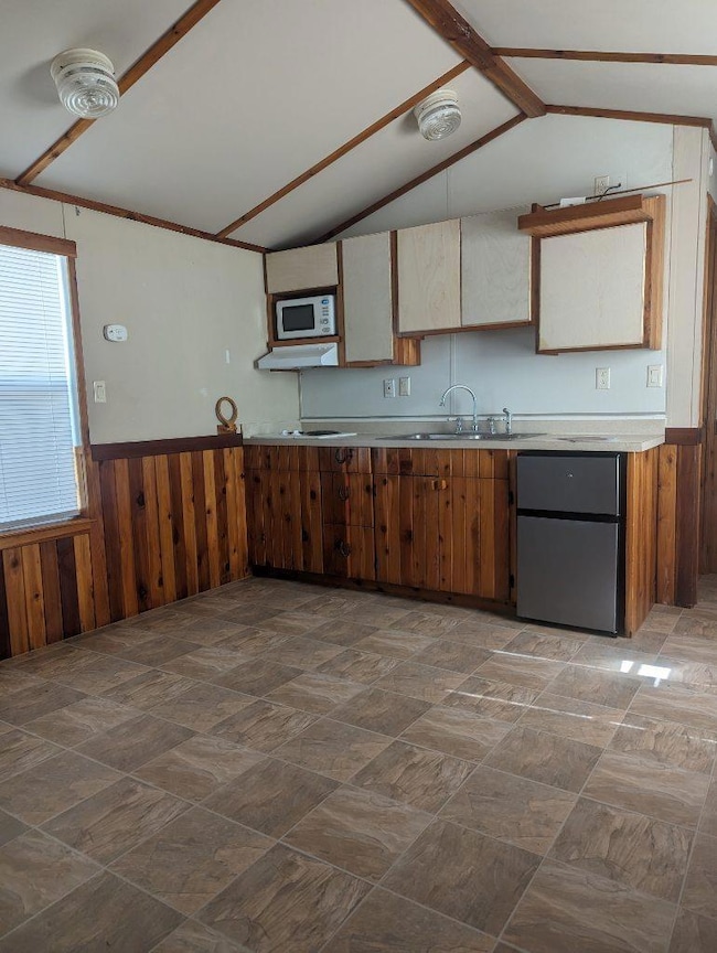 Kitchen featuring a sink, freestanding refrigerat