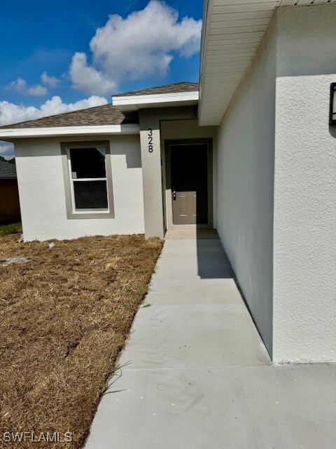 View of exterior entry featuring stucco siding