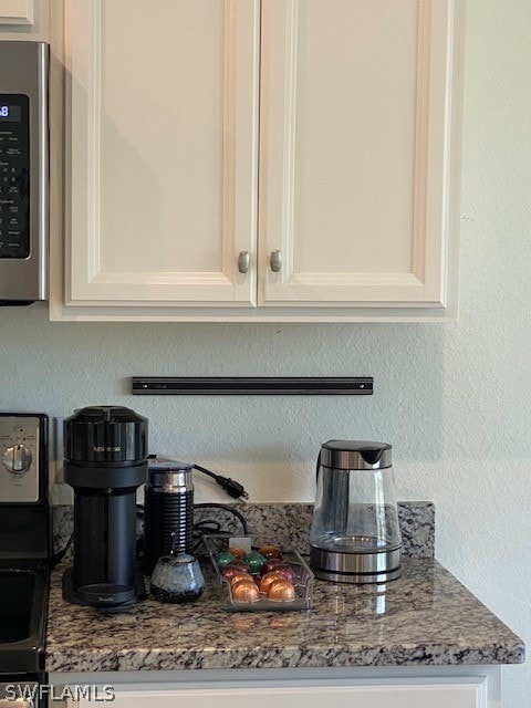 Room details featuring white cabinets and stone co