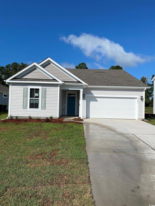 View of front facade featuring a garage and a yard