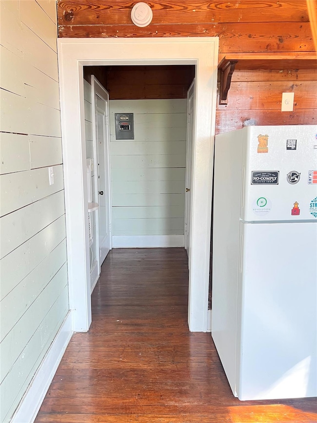 Corridor featuring wood walls and dark wood-style
