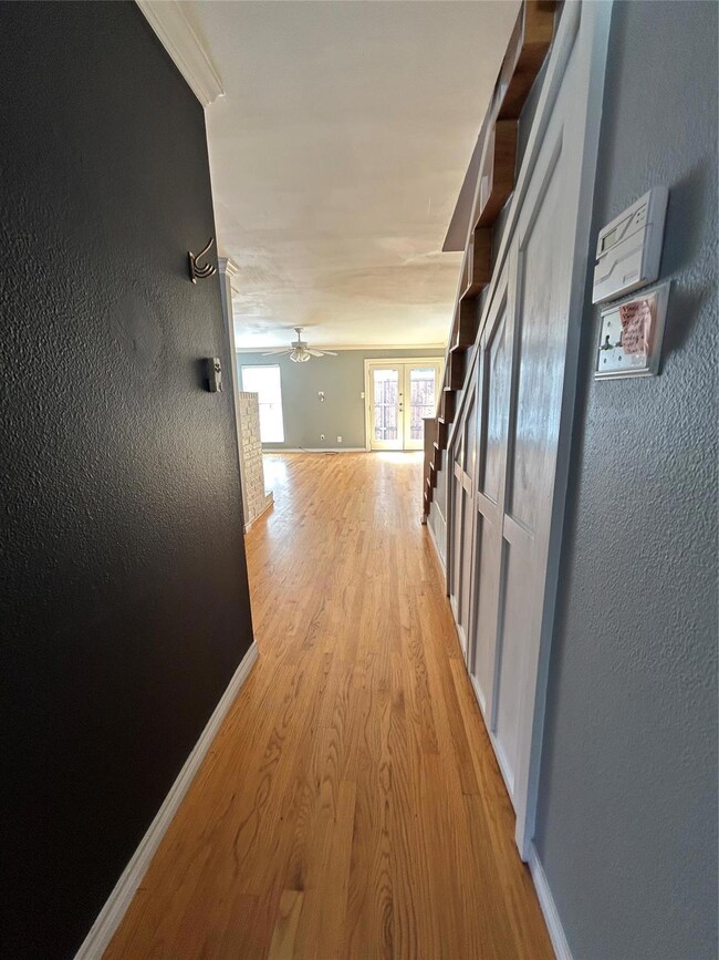 Corridor with light wood-type flooring, baseboards