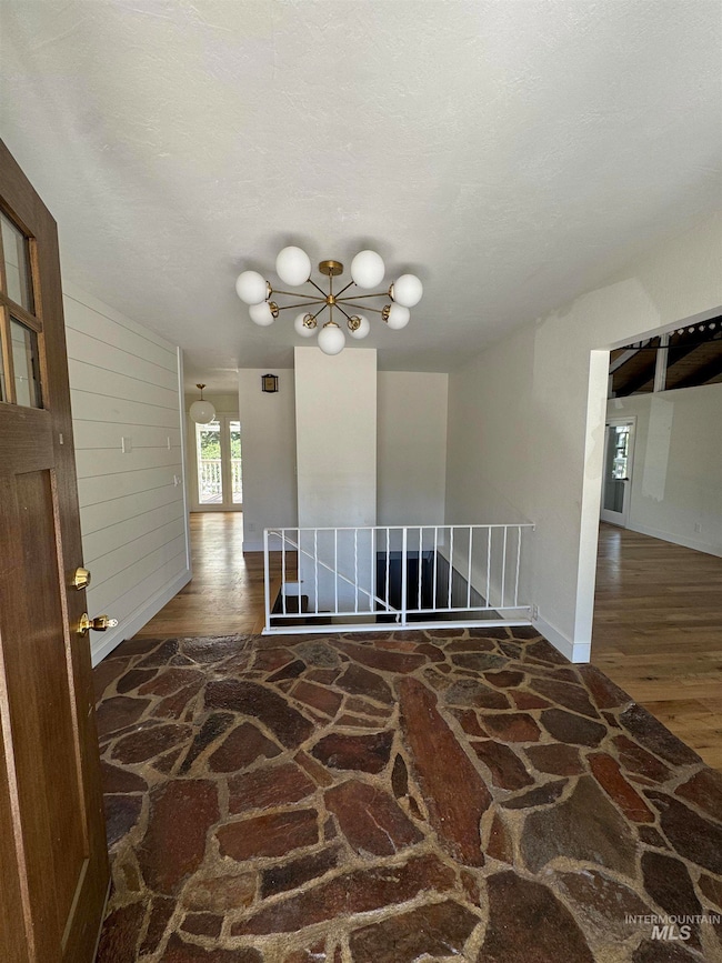 Empty room featuring wood finished floors and a chandelier