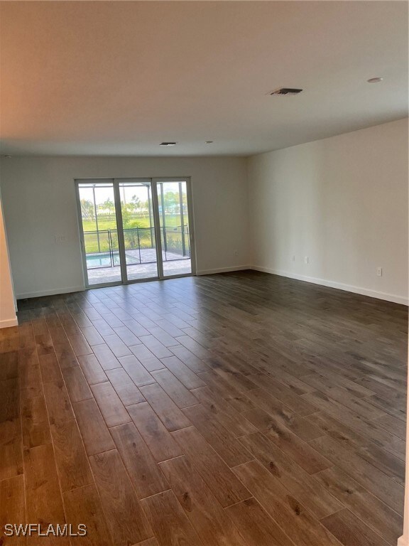 Unfurnished room with dark wood-type flooring