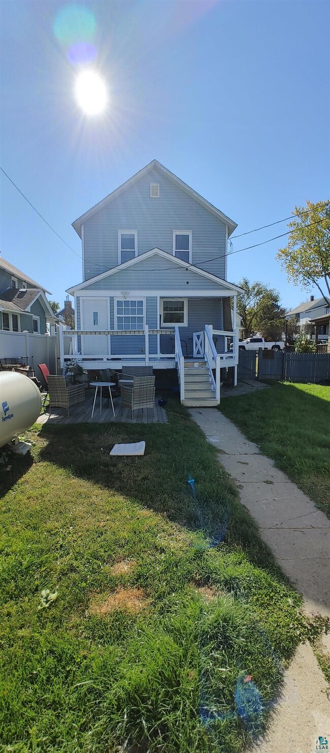 View of back of house featuring a rear yard and a 