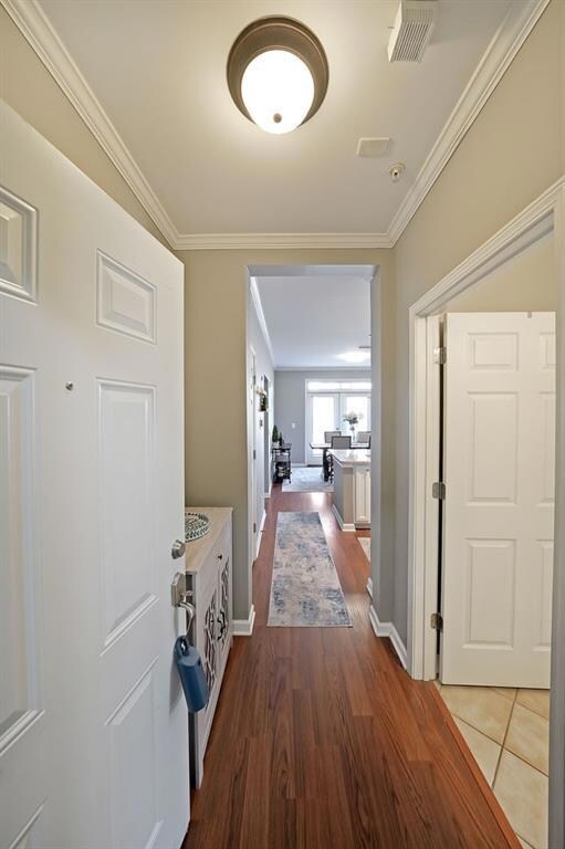 Hallway with baseboards, dark wood-style floors, v