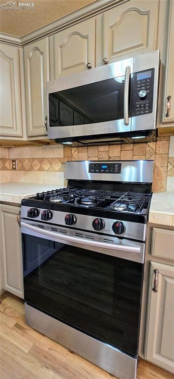 Kitchen with stainless steel appliances, cream cab