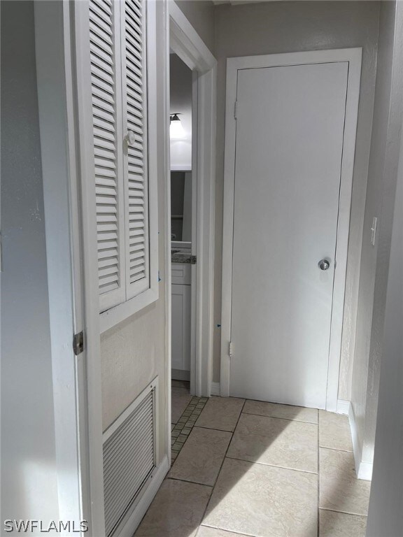 Hallway featuring light tile floors
