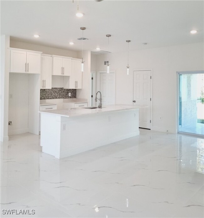 Kitchen with pendant lighting, a large island, whi
