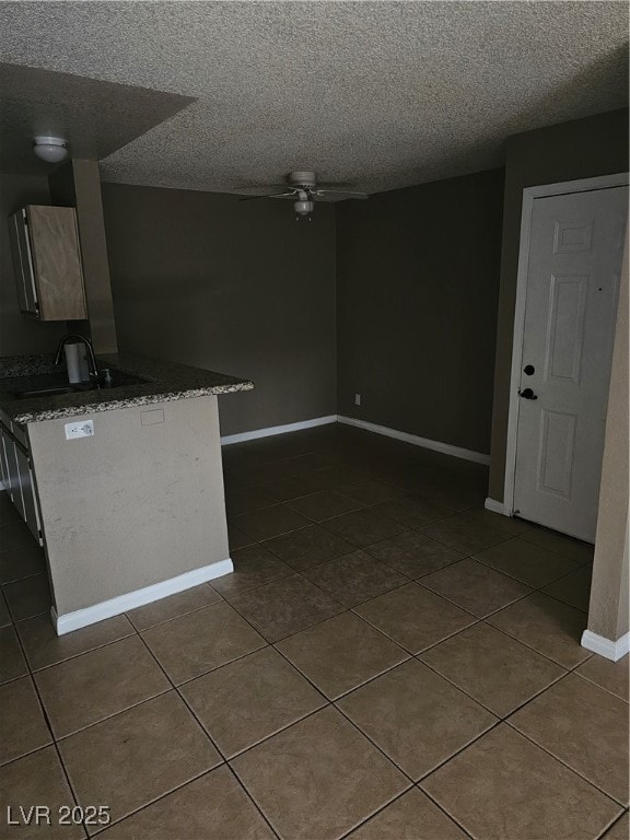 Kitchen with dark tile patterned flooring and a te