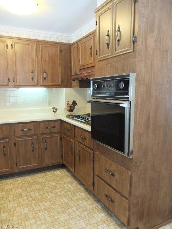 Kitchen has countertop range and wall oven.