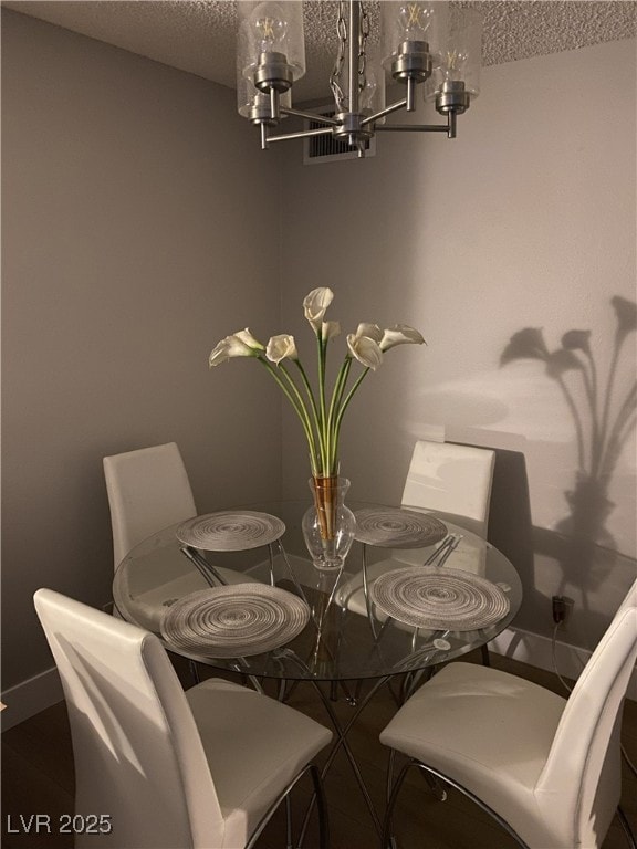 Dining room with a chandelier and a textured ceiling