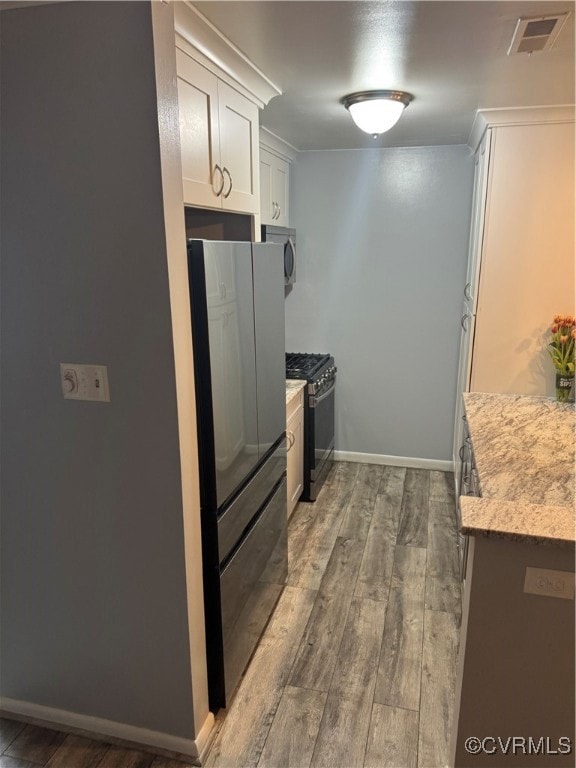 Kitchen with gas range oven, fridge, LVP finished