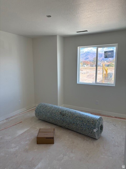Bedroom featuring a textured ceiling and baseboards