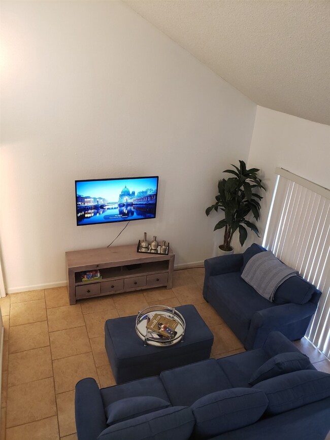 This cozy living room features a high ceiling, til