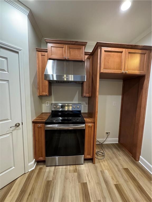 Kitchen with ventilation hood, range, light wood f