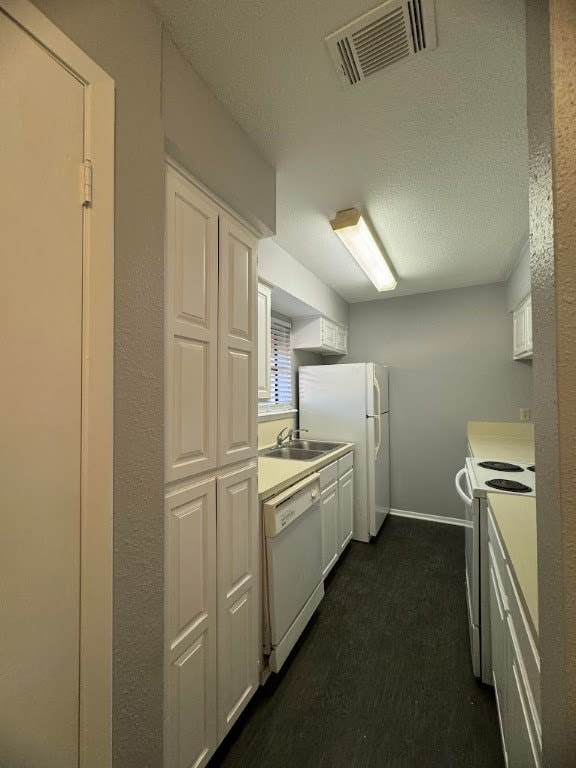 Kitchen featuring a textured ceiling, white applia