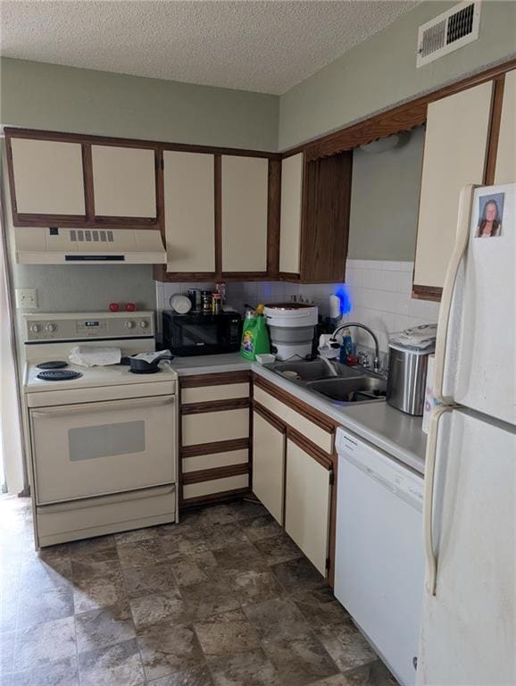 Kitchen featuring white appliances, white cabinetry, light countertops, exhaust hood, and stone finish flooring